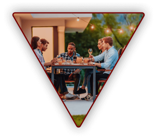 Group of young adults eating dinner outside on a calm summer evening